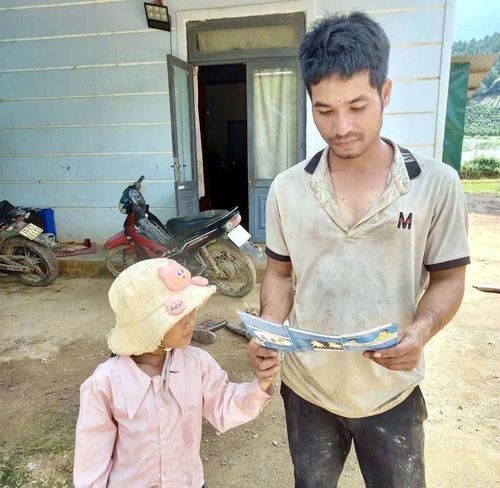 Một người cha đọc tài liệu để biết cách phòng bệnh TCM cho con trẻ trong gia đình