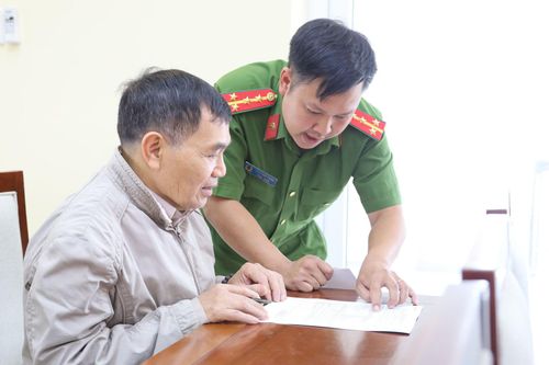 Lực lượng chức năng hỗ trợ thân nhân liệt sĩ điền thông tin làm thủ tục lấy mẫu sinh phẩm ADN