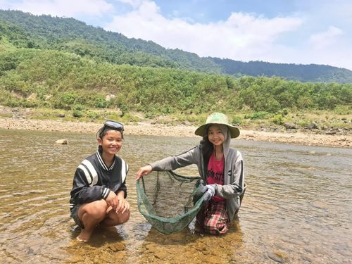 Em Hồ Thị Diêu, Hồ Thị Linh đang vợt cá bống - Ảnh: S.H