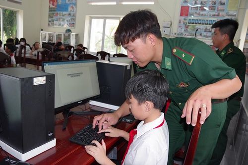 Cán bộ Đồn Biên phòng Vĩnh Hải hướng dẫn học sinh sử dụng internet phục vụ học tập.