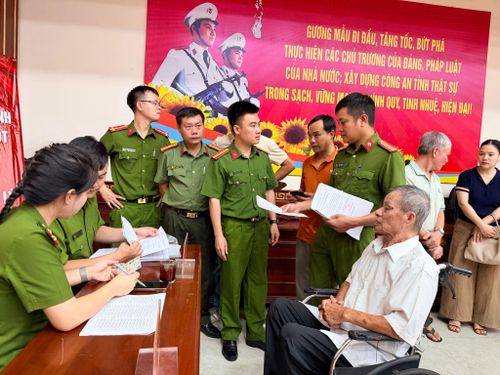 Lực lượng công an tra cứu thông tin, hướng dẫn thân nhân liệt sĩ quy trình khai báo, lấy mẫu ADN. Ảnh: Minh Phương