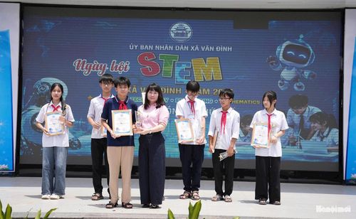 Phó Chủ tịch UBND xã Vân Đình Phạm Thúy Hòa trao giải Nhất cho đại diện học sinh Trường THCS Nguyễn Thượng Hiền. Ảnh: Lại Tấn