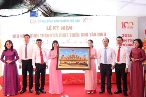 Trao vật phẩm lưu niệm cho Ban Giám đốc Trung tâm cung ứng dịch vụ công phường Tân Định, đại diện cho hàng trăm thương nhân đồng hành, gắn bó với chợ Tân Định thời gian qua. (Ảnh: Phường Tân Định)