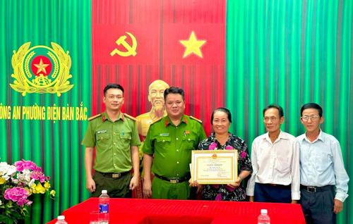 Công an phường Điện Bàn Bắc trao Giấy khen cho bà Thọ.