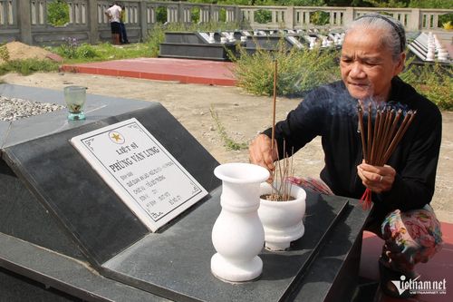 Bà Cúc bên phần mộ liệt sĩ Phùng Văn Lung ở Nghĩa trang liệt sĩ Tam Sơn