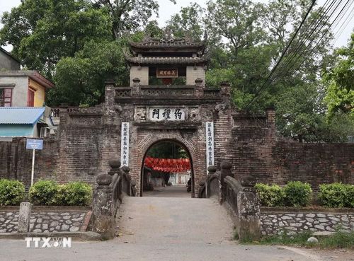 Cổng làng Ước Lễ với kiến trúc cổ kính, phía trước là cây cầu bắc qua con mương - yếu tố góp phần tạo nên không gian đặc trưng của cổng làng Bắc Bộ xưa. (Ảnh: Vũ Quang/TTXVN)