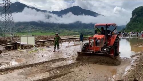 Lực lượng chức năng đã sử dụng máy xúc để khơi thông đoạn đường Quốc lộ 32. Ảnh: Đức Bình/Nông nghiệp và Môi trường