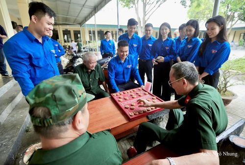 Dưới mái hiên nhà, các cựu chiến binh đang đánh cờ trong niềm vui tuổi già.