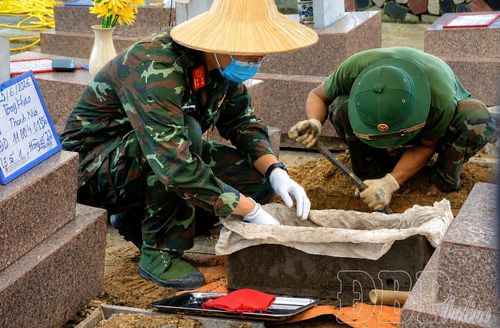 Lực lượng chức năng thu nhận mẫu sinh phẩm từ hài cốt liệt sĩ phục vụ giám định.