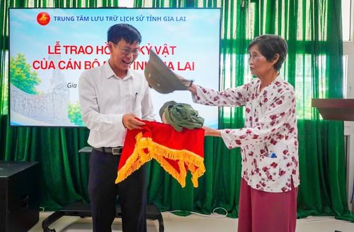  Bà Thái Thị Thự trao tặng lại kỷ vật (mũ và chiếc ba lô) gắn với những năm tháng hoạt động cách mạng của bố mình cho Trung tâm Lưu trữ lịch sử tỉnh Gia Lai làm hiện vật trưng bày. Ảnh: Dũng Nhân 
