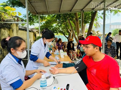 Đội ngũ y, bác sĩ đo huyết áp cho người tới khám bệnh.