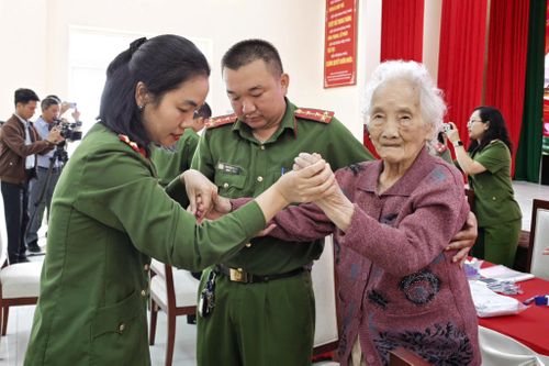 Các chiến sĩ dìu đỡ, hỗ trợ thân nhân liệt sĩ cao tuổi đến từng bàn lấy mẫu