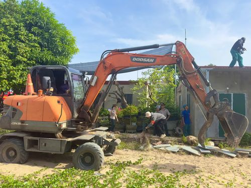 Lực lượng chức năng tiến hành tháo dỡ các công trình trên diện tích đất phải thi hành án - Ảnh: Thùy Trang