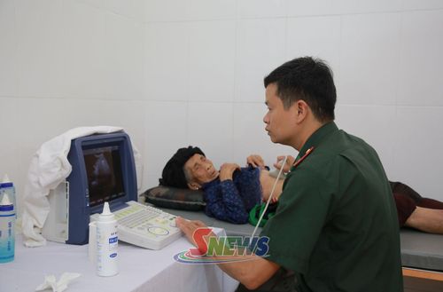 Cán bộ Trạm xá Quân dân y hữu nghị biên giới Việt - Lào khám bệnh cho bệnh nhân chính sách ở xã Lóng Sập.