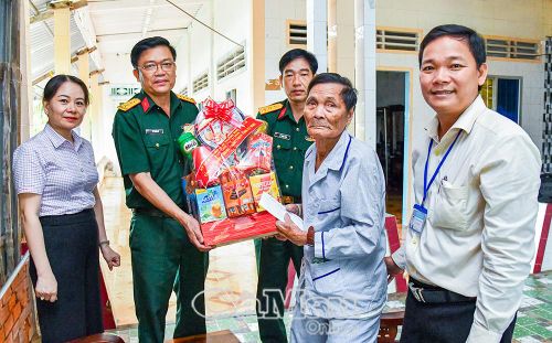 Đại tá Võ Thành Lê, Chính uỷ Bộ CHQS tỉnh Cà Mau, thăm, tặng quà ông Nguyễn Hữu Trung, thương binh 3/4 ở xã Tân Hưng.