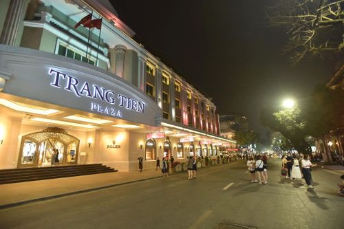 Hoạt động thương mại và giải trí vận hành trong khung thời gian từ 22h hôm trước đến 2h hôm sau tại khu vực được phép. Theo điểm b, c, khoản 1 Điều 10 Nghị quyết 34/2026/NQ-HĐND, việc kéo dài thời gian hoạt động sau 22h hôm trước đến 2h hoặc 6h hôm sau chỉ áp dụng có chọn lọc tại các khu vực tách biệt, đáp ứng tiêu chuẩn khắt khe về an ninh, cách âm và quản lý đô thị. (Ảnh: Trung tâm thương mại Hoàn Kiếm rực sáng về đêm)