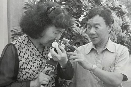 Bà Hiên xúc động khi nhận lại chiếc máy ảnh của chồng. Ảnh chụp từ sách.