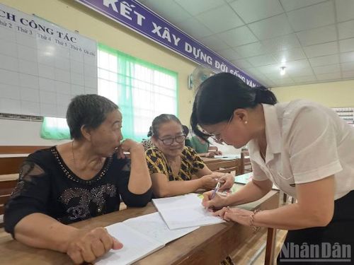 "Cô giáo" Đào Thị Thanh An hướng dẫn bà Trần Thị Sen (áo đen) và bà Nguyễn Thị Huyên viết chữ.