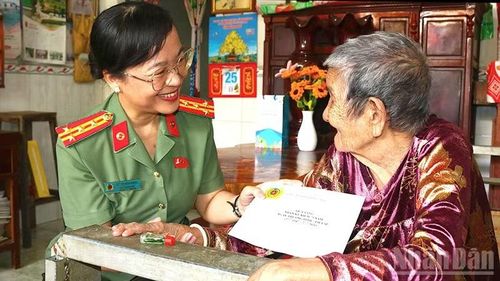 Đại tá Võ Thị Hoài Ngọc, Phó Giám đốc Công an tỉnh Đồng Tháp trao quà của Bộ Công an tặng Mẹ Việt Nam anh hùng Huỳnh Thị Trinh.