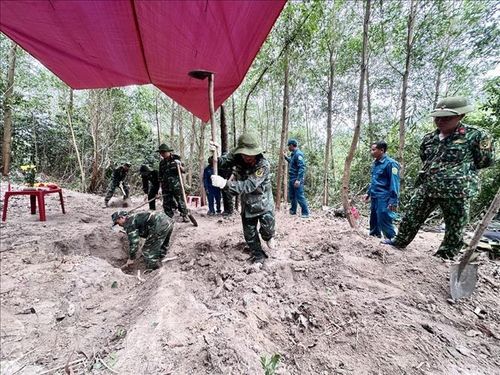 Các thành viên Đội K51 Đắk Lắk và các lực lượng cẩn thận đào từng lớp đất để tìm kiếm, quy tập hài cốt liệt sĩ trong Chiến dịch 500 ngày đêm. Ảnh: TTXVN phát
