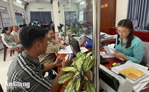 Công chức Trung tâm Phục vụ hành chính công phường Vĩnh Thông hướng dẫn người dân đăng ký giấy phép kinh doanh bằng dịch vụ công trực tuyến. Ảnh: CẨM TÚ