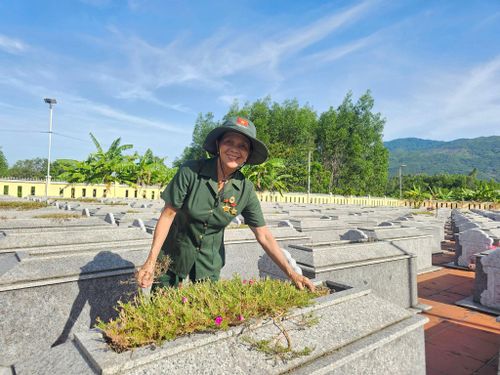 Bà Lê Thị Bốn thường xuyên hương khói, chăm sóc các phần mộ ở Nghĩa trang liệt sĩ Đại Đồng. Ảnh: LAM PHƯƠNG