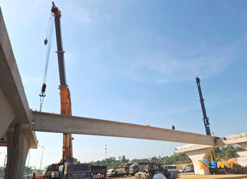Lao lắp dầm cầu chính vượt cao tốc. Ảnh: CÔNG TÚ - XUÂN SƠN