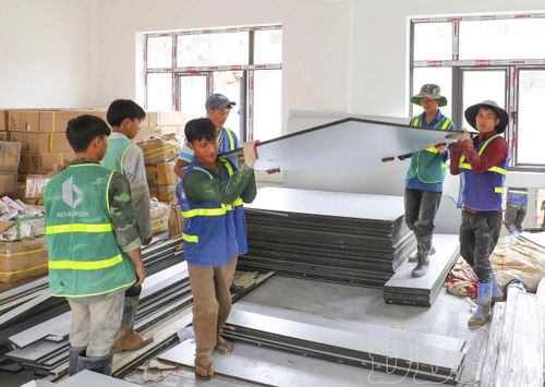 Công nhân Công ty TNHH Thương mại và Xây dựng số 6 thi công hạng mục lắp đặt đồ dùng, thiết bị phục vụ học tập thuộc dự án Trường Phổ thông nội trú liên cấp Tiểu học và THCS xã Thanh Nưa.