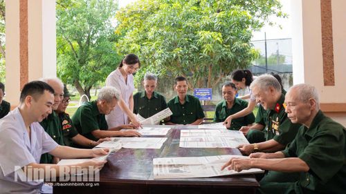 Các thương bệnh binh cùng cán bộ, điều dưỡng viên cơ sở Điều dưỡng thương binh Nho Quan đọc và thảo luận tin tức trên báo. Ảnh: Ngọc Linh