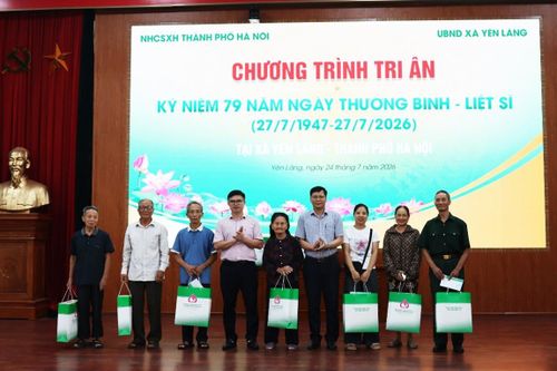 Phó Giám đốc NHCSXH thành phố Hà Nội Đặng Đức Hạnh và Phó Chủ tịch HĐND xã Yên Lãng Phạm Thành Đô trao quà cho các gia đình người có công