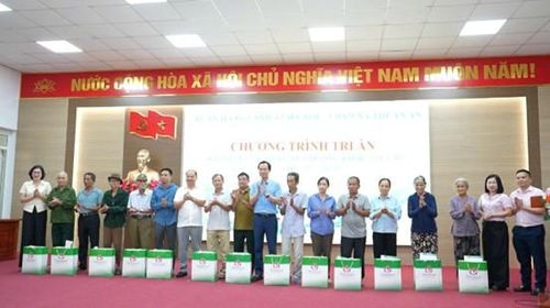 Lãnh đạo NHCSXH thành phố Hà Nội và lãnh đạo xã Thuận An trao quà cho người có công