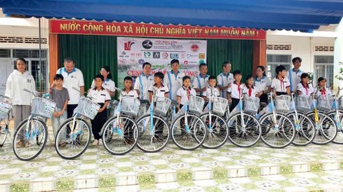 Các đại biểu trao xe đạp cho các em học sinh vượt khó