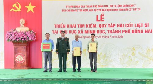 Lực lượng trực tiếp thực hiện nhiệm vụ, các nhân chứng lịch sử và người cung cấp thông tin tìm kiếm, quy tập hài cốt liệt sĩ ở xã Minh Đức được tặng quà từ cơ quan chức năng. (Ảnh: Lương Ý) 