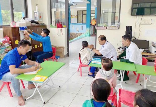 BSCK1 Lê Văn Danh (thứ 2 bên phải sang) khám sức khỏe định kỳ với học sinh Trường Mầm non-Tiểu học Hoa Phong Ba ở đặc khu Cồn Cỏ - Ảnh nhân vật cung cấp.