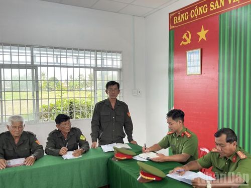 Ông Si Phon báo cáo tình hình an ninh, trật tự trên địa bàn trong cuộc họp của Đội dân phòng cơ động và lực lượng chức năng.