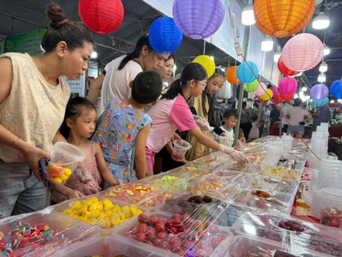 Không chỉ trẻ em, người lớn cũng hào hứng trải nghiệm mua sắm tại gian hàng dành cho trẻ thơ. Ảnh: P.T