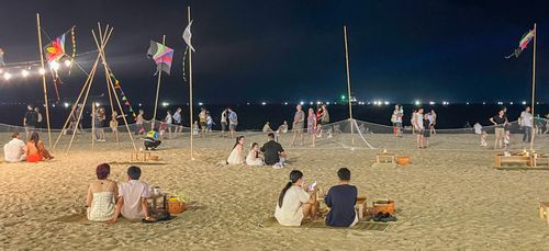 Đông đảo người dân, du khách ngồi bên bờ biển, tận hưởng không khí đêm hè Đà Nẵng