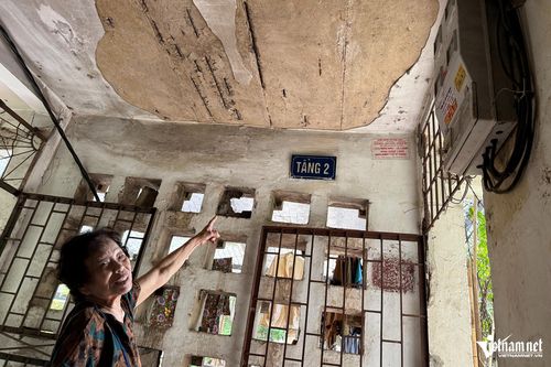 Bà Nghĩa chỉ tay về phía trần nhà bị bong tróc. Ảnh: Kiều Oanh