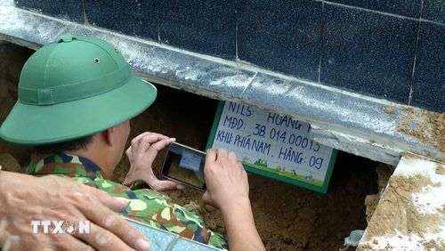 Tổ lấy số hóa thông tin tiến hành ghi nhận, chụp ảnh và số hóa dữ liệu mộ liệt sỹ tại Nghĩa trang Liệt sỹ Hoằng Hóa, phục vụ công tác giám định ADN, xác định danh tính hài cốt liệt sỹ còn thiếu thông tin. (Ảnh: Khiếu Tư/TTXVN)