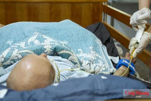 Điều dưỡng Nguyễn Thị Lan Phương hỗ trợ bác Vũ Kim Phiên, một trong những trường hợp nặng đang được chăm sóc tại trung tâm, ăn qua ống sonde.