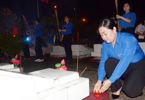 Chị Thị Phương Hồng thắp nến tri ân tại các phần mộ liệt sĩ.