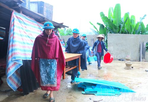 Chính quyền, dân quân tự vệ, người dân bản Bua giúp gia đình chị Lò Thị Mai di dời tài sản đến nơi an toàn. 