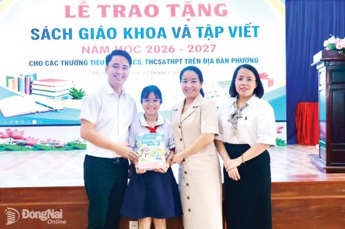 Em Phạm Ngọc Gia Hân, học sinh Trường TH-THCS Minh Long (phường Minh Hưng) nhận sách giáo khoa trước năm học 2026-2027.