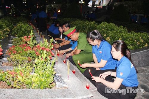 Đại biểu thắp hương và thắp nến tại các phần mộ liệt sĩ. 