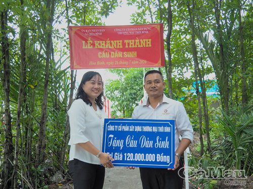  Đồng chí Đỗ Ái Nam, Phó Bí thư Đảng uỷ, Chủ tịch UBND xã Hoà Bình, nhận bảng tượng trưng tặng công trình cầu từ nhà tài trợ.