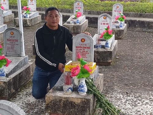 Anh Nguyễn Công Quỳnh bên mộ người bác ruột là liệt sĩ Nguyễn Công Hòa.