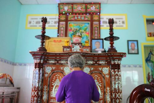 Bà Lệ thắp nén nhang trên bàn thờ gia tiên nhà họ Huỳnh sáng 7/7. Nơi thờ cúng không có di ảnh liệt sĩ Huỳnh Văn Quên, chỉ có Bằng Tổ quốc ghi công được gia đình nâng niu gìn giữ như sự hiện diện của người con đã hy sinh. Ảnh: Quỳnh Danh 