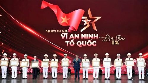 Thượng tá Bùi Quang Vinh (thứ 4 từ trái sang) đón nhận danh hiệu Anh hùng Lực lượng vũ trang nhân dân của cha mình - liệt sĩ Bùi Huy Giáp (Ảnh: V. Quang).
