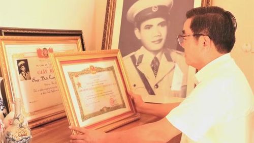 Thượng tá Bùi Quang Vinh bên những chứng nhận về thành tích trong chiến đấu, công tác của Anh hùng Lực lượng vũ trang nhân dân Bùi Huy Giáp.