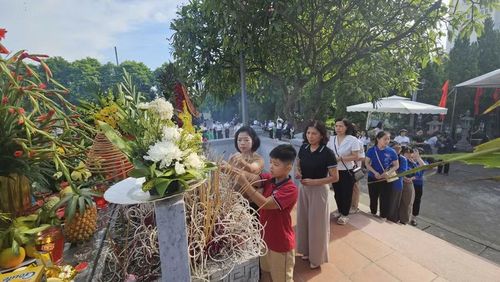 Đại diện học sinh và thầy cô giáo thắp hương tri ân các anh hùng liệt sĩ tại Nghĩa trang liệt sĩ xã An Khánh, Hà Nội sáng 27/7.